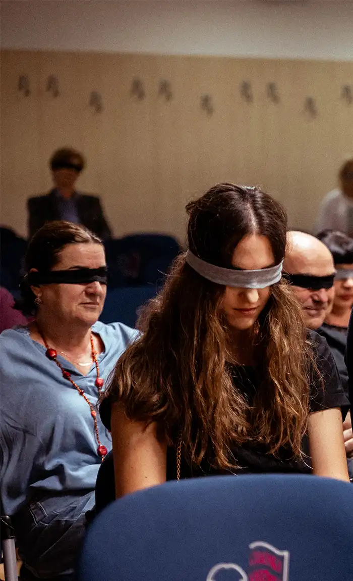 People listening to Nera reading her book while blindfolded 